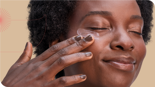 mulher com os olhos fechados aplicando um creme na região dos olhos